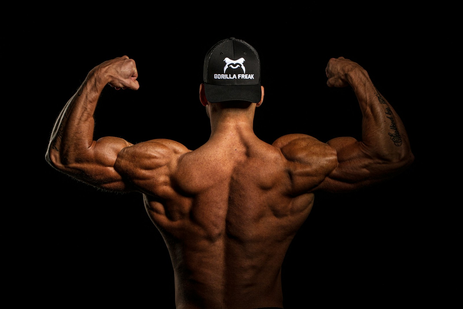topless man wearing black and white cap